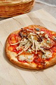 Pizza with blue cheese, onions and enoki mushrooms