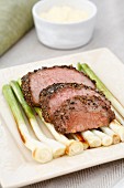 Peppered steak with oven-roasted spring onions