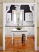 Decorated doorway with white wooden frame and view of traditional kitchen table in country house kitchen