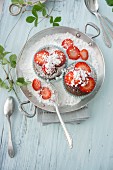 Chocolate muffins with strawberry jam and icing sugar