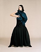 Junge Frau in langem schwarzen Kleid mit Wolltuch um Schultern