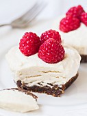 Mini vegan cheesecakes made with cashew nuts, coconut cream and dates and decorated with raspberries