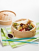 Pancake rolls with Peking duck and spring onions in a bamboo steamer