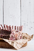 A raw rack of lamb on a piece of paper