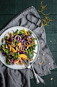 Winter salad with green and red cabbage, oranges, onions and walnuts