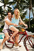 A young couple sitting on a bike together