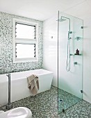 Modernes Bad mit freistehender Wanne, ebenerdiger Dusche und Mosaikfliesen