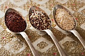 Verschiedene Arten von Quinoa in drei Löffeln