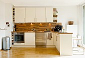 Moderne offene Küche mit hellen Fronten und Holzplatte
