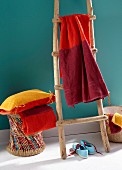 Handtuch in verschiedenen Rottönen gefärbt, auf Holzleiter gehängt