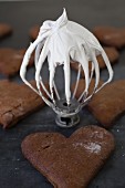 Gingerbread hearts and a whisk with an icing sugar-egg white glaze