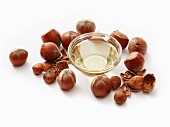 A bowl of hazelnut oil surrounded by hazelnuts