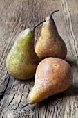 Three Concorde pears on a rustic wooden table