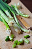 Spring onions on a wooden chopping board