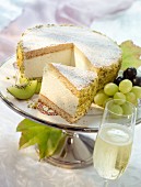 A creamy cheesecake garnished with kiwis and grapes