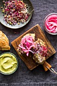 Sandwiches with avocado cream, beansprouts and pickled red onions