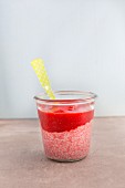 Strawberry, coconut and chia pudding and glass with a spoon