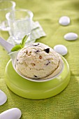 A scoop of walnut ice cream with basil on a spoon