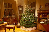 Klassisch geschmückter Weihnachtsbaum im traditionellen Wohnraum mit antiken Möbeln