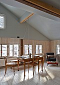 Renoviertes Esszimmer in einem alten Holzhaus mit offenem Dach und Biedermeiermöbeln