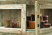 Jars of jam in rustic wooden cupboard