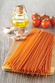Ungekochte Tomaten-Spaghetti auf Holzbrett