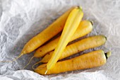 Yellow carrots on a piece of white parchment paper