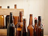 Open beer bottles in front of a wooden crate