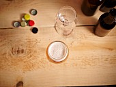 Biergläser, Kronkorken und Bierflaschen auf Holzuntergrund