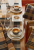 Tartan tablecloth on coffee table and matching scatter cushions on chairs