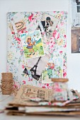 Vintage-style clippings from French magazines on floral fabric pinboard