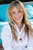 A young blonde woman wearing a white blouse