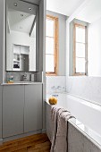 Marble bathtub and narrow sink in small bathroom