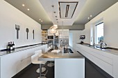 Island counter and long, minimalist base units in modern kitchen