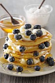 A stack of pancakes with ricotta, syrup and blueberries