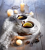 Mulled wine in white cups by candlelight