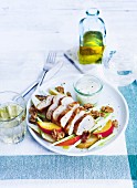Marinated chicken breast on a peach salad with spring onions and walnuts