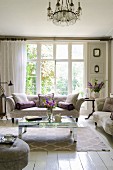 Classic upholstered furniture, mirrored coffee table and lattice windows in elegant living room