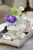Gold-rimmed cups and delicate flowers on vintage-style silver tray
