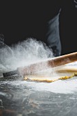 Flour on a work surface with a rolling pin and shortcrust pastry