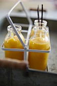 Persimmon and melon smoothies in a bottle carrier