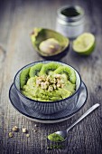 A smoothie bowl with fruit purée, avocado, matcha and almond crunch