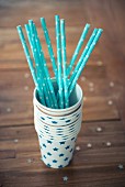 Blue straw in a stack of paper cups decorated with stars