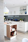 White, glossy modern kitchen with glass splashbacks and island counter