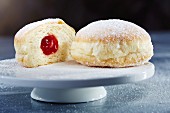 Doughnuts with icing sugar and jam, whole and halved