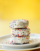 A stack of white glazed butter biscuits and colourful sugar sprinkles