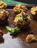 Mini broccoli muffins on a baking tray (close-up)