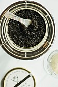 A jar of black caviar with a mother-of-pearl spoon