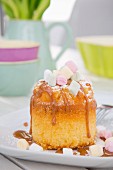 A mini sponge cake with caramel sauce and marshmallows