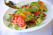 A heirloom tomato salad with rocket, balsamic vinegar and olive oil